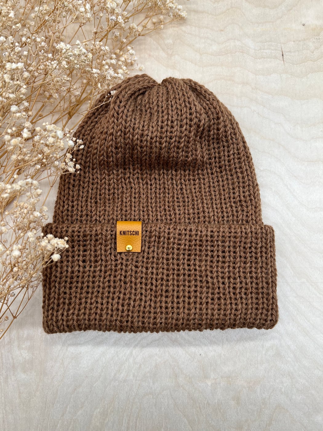 Genuine KNITSCHI hat in natural brown with visible rib texture and brand label