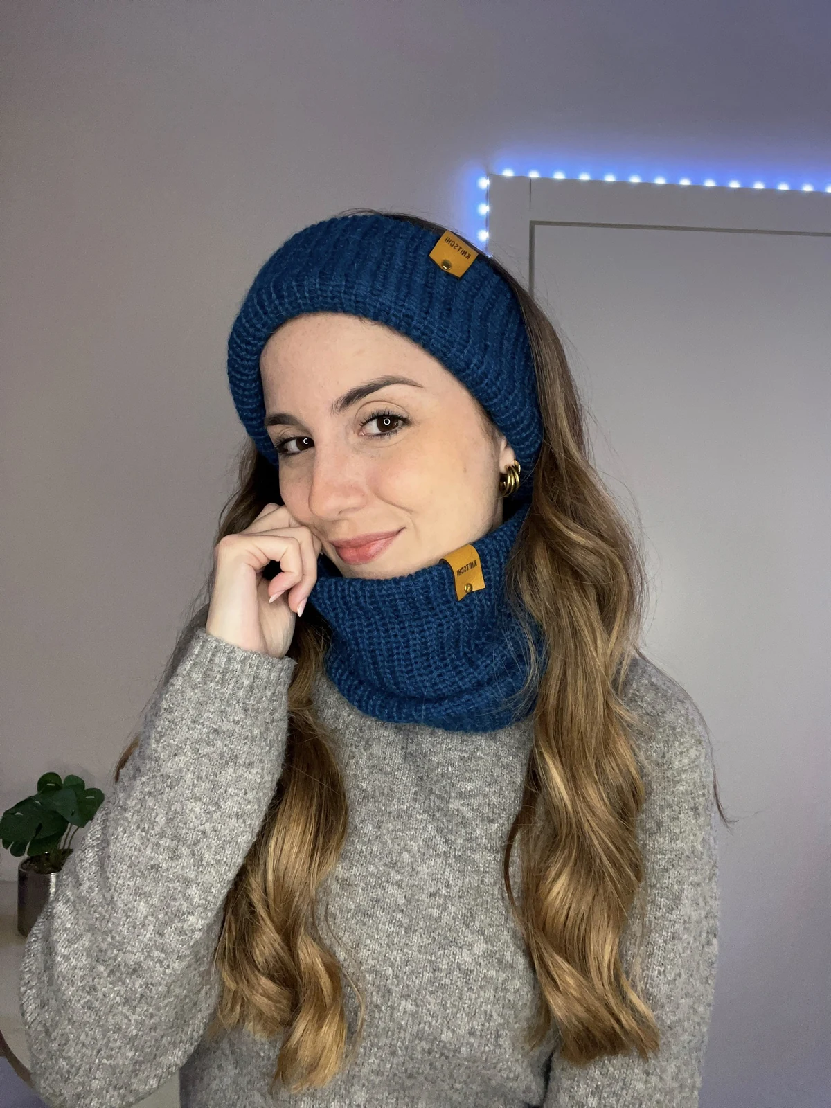Model mit petrolblauer KNITSCHI 2-in-1-Lösung aus Alpakawolle
