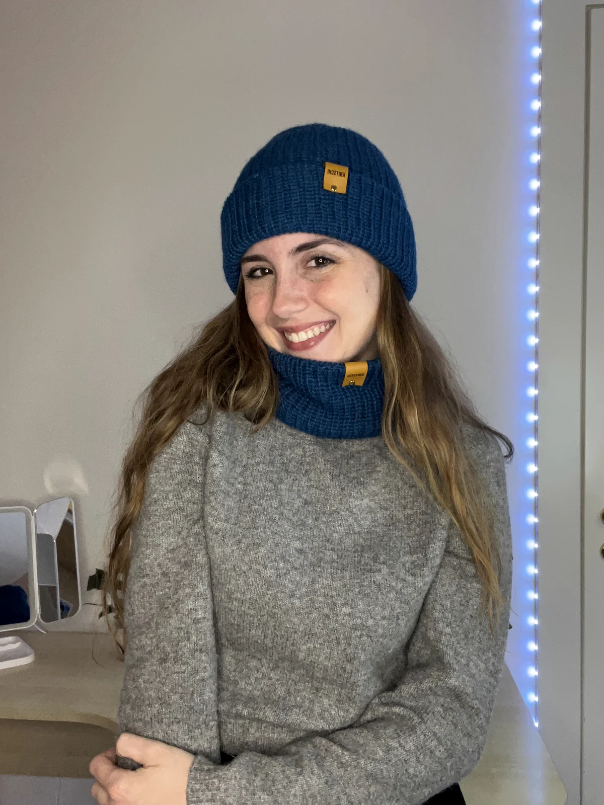 Model mit petrolblauer KNITSCHI-Mütze und passendem Loop