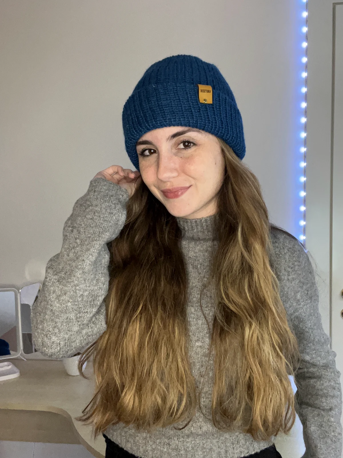 Model mit petrolblauer KNITSCHI-Mütze aus Alpakawolle