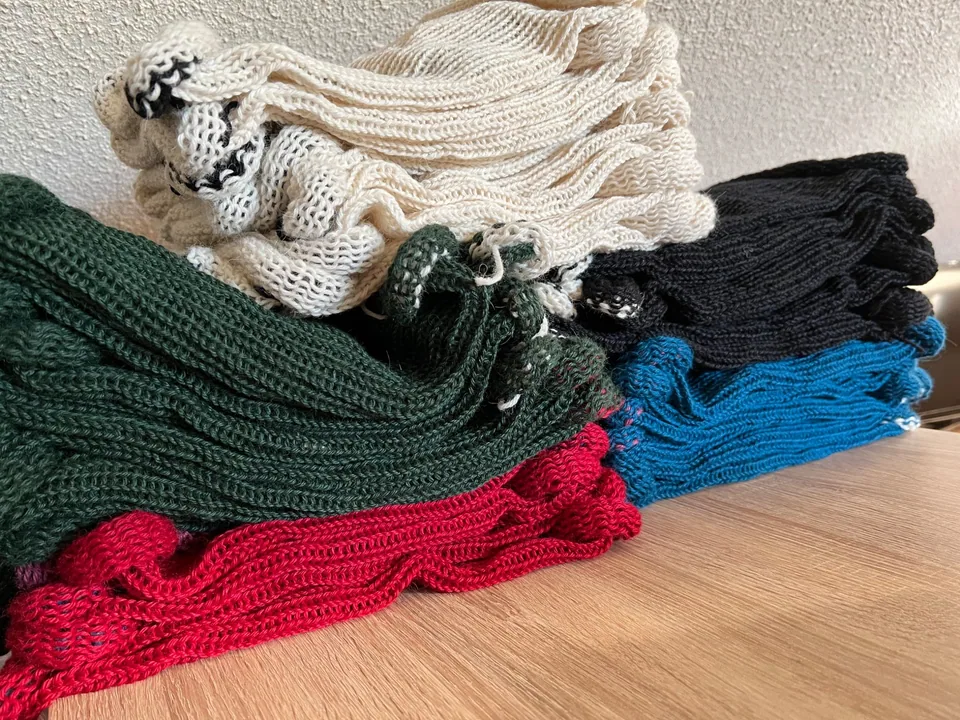 Mehrere gestrickte Stulpen warten auf die Fertigstellung zu Loops